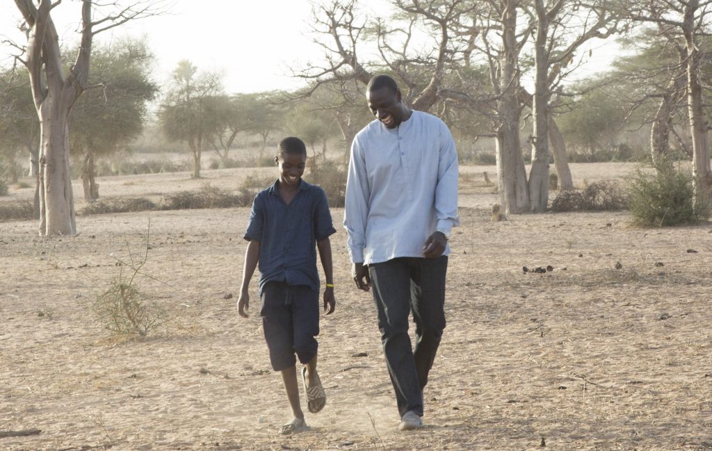 Scena del film Il Viaggio di Yao: personaggi in un contesto africano durante il viaggio